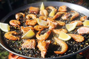 Paella negra with salmon and prawns 